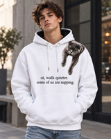 Man wearing a white VZAEMOA graphic hoodie with grey shoulder cat artwork outdoors